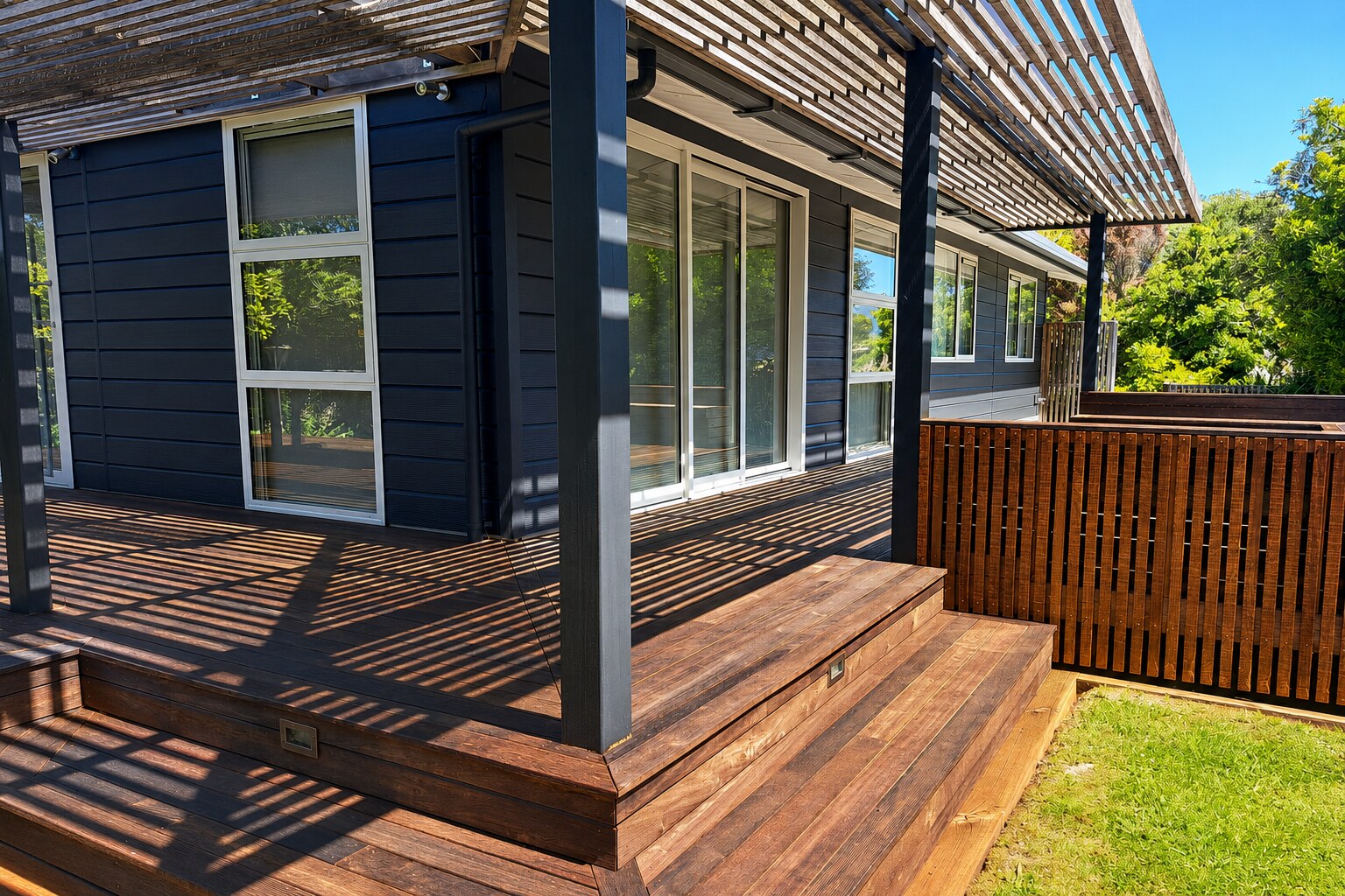 golden bay dark weatherboard house timber deck
